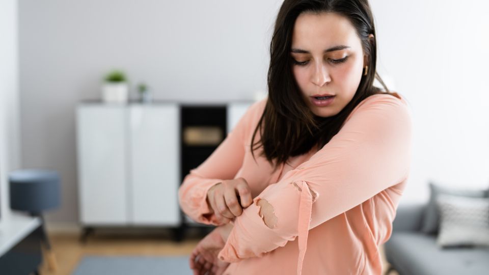 a woman discovering that her clothes have holes in them poor quality