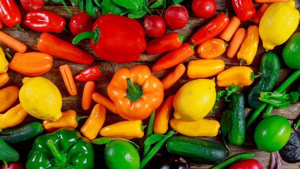Fruits and vegetables on a table and organised into colours.