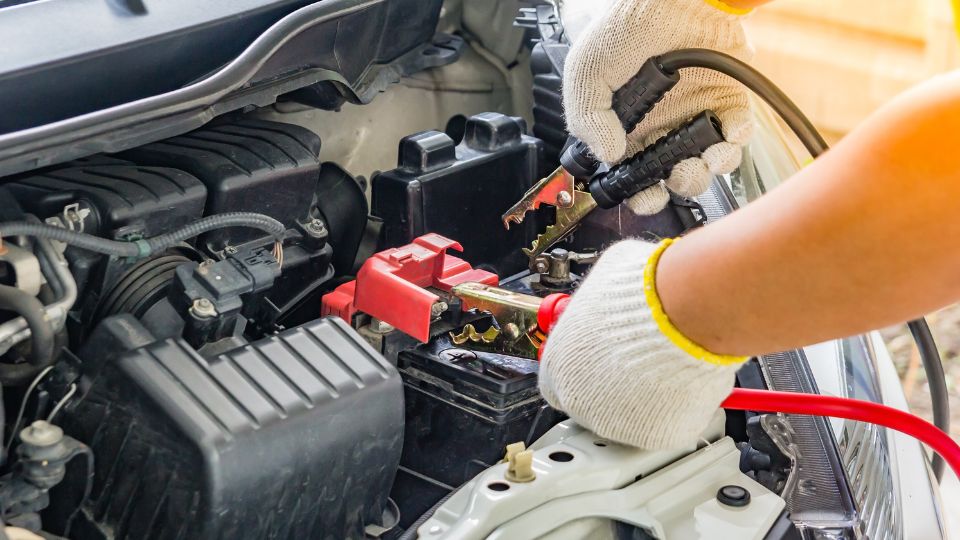 Car battery being jump started with leads.