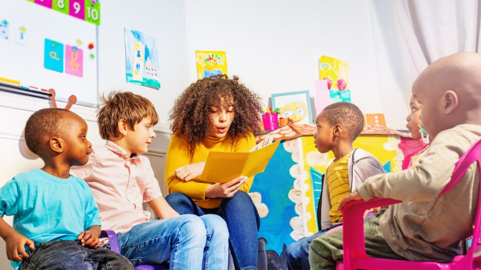 Inside a nursery where an employee is reading to children
