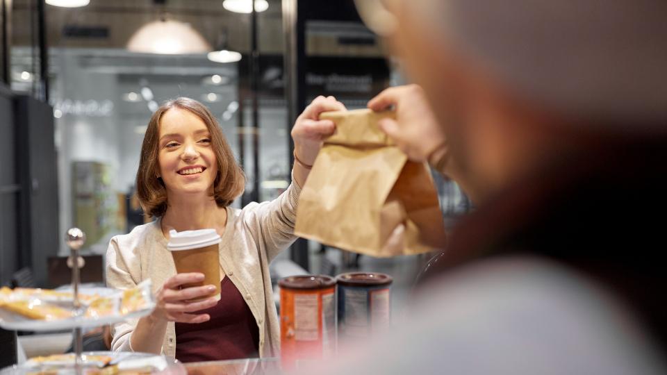 Woman being handed a takeaway bag